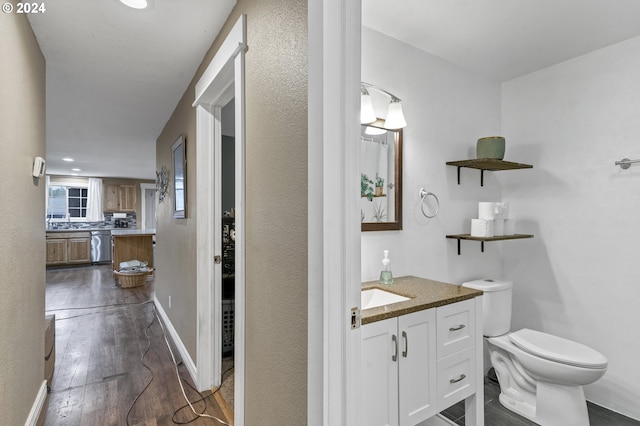 bathroom featuring vanity, wood-type flooring, and toilet