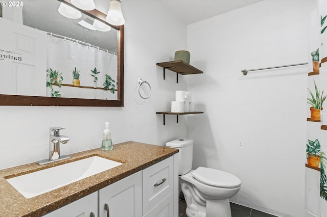 bathroom featuring tile patterned flooring, vanity, and toilet