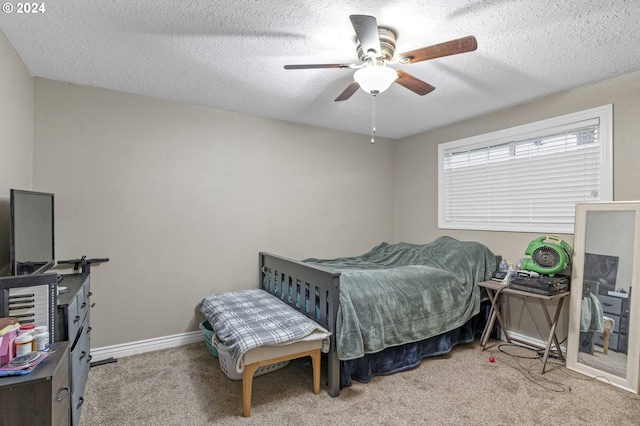 carpeted bedroom featuring ceiling fan and a textured ceiling