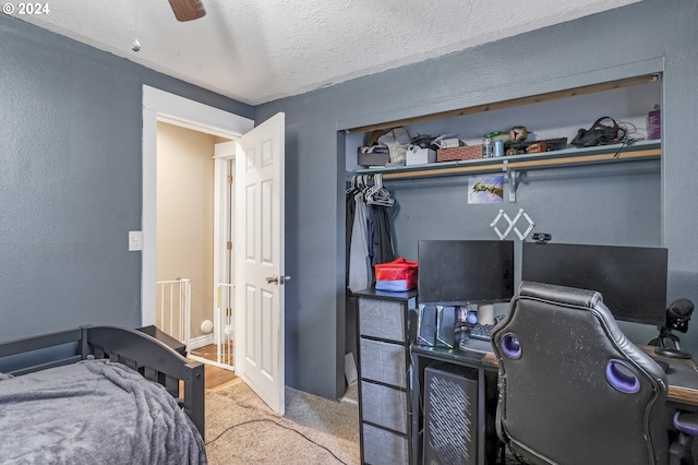 bedroom with ceiling fan, light carpet, and a textured ceiling