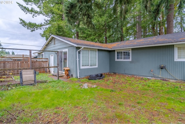 rear view of house featuring a yard