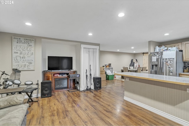 living room featuring a barn door and light hardwood / wood-style flooring