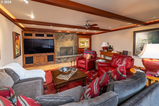 living room with beamed ceiling, hardwood / wood-style flooring, ceiling fan, and a fireplace