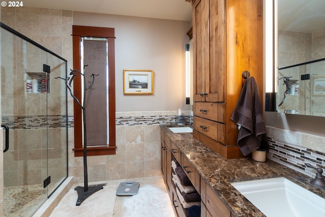 bathroom with tile walls, vanity, and a shower with shower door