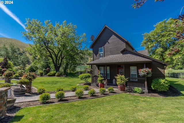 back of property featuring a porch and a lawn