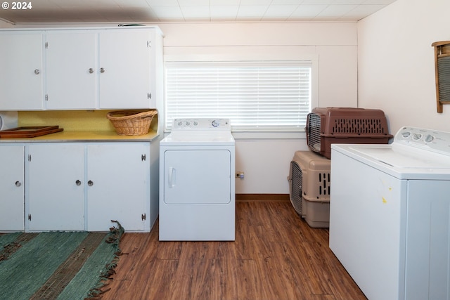 laundry area featuring cabinets, dark hardwood / wood-style floors, and washer and dryer