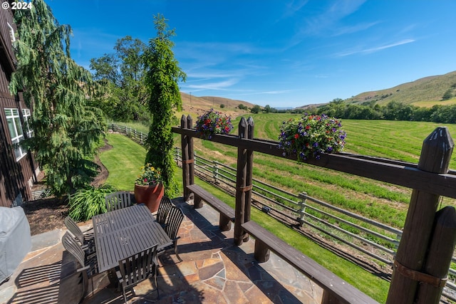 balcony with a mountain view, a rural view, and a patio area