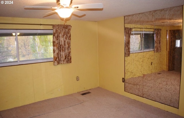 empty room with ceiling fan and carpet flooring