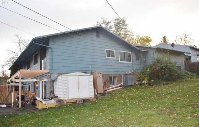 back of property featuring a storage unit and a yard