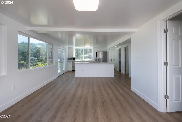 kitchen featuring appliances with stainless steel finishes, a kitchen island, white cabinetry, and hardwood / wood-style floors