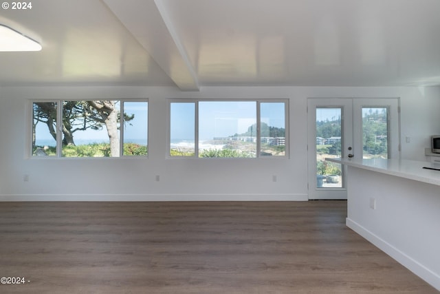 unfurnished living room with vaulted ceiling with beams and dark wood-type flooring