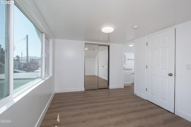 unfurnished bedroom with hardwood / wood-style flooring, a closet, and connected bathroom