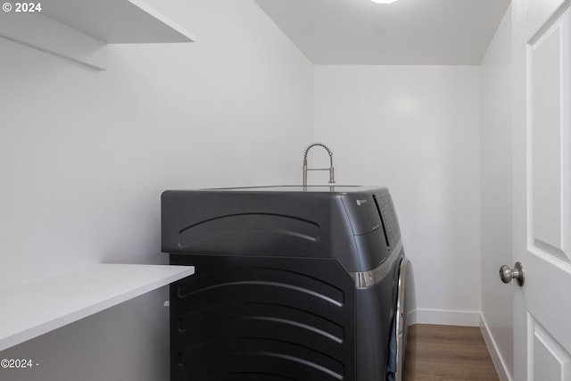 clothes washing area featuring washing machine and clothes dryer and dark hardwood / wood-style flooring