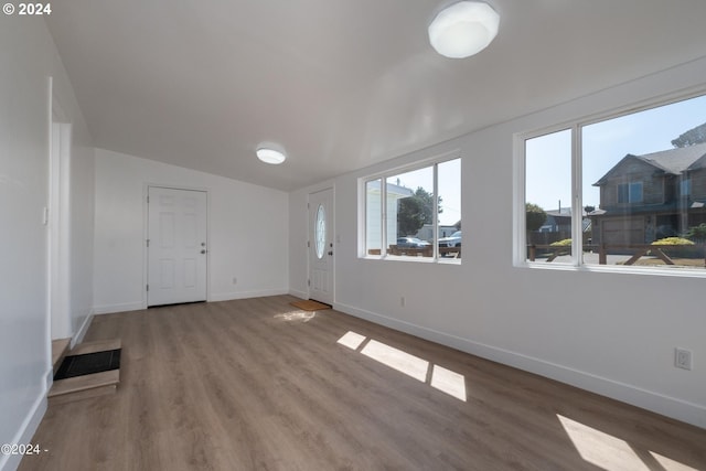 spare room with wood-type flooring and vaulted ceiling