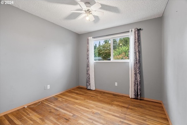 empty room with ceiling fan, a textured ceiling, and light hardwood / wood-style flooring