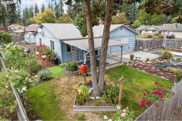 back of house featuring a lawn and a patio area