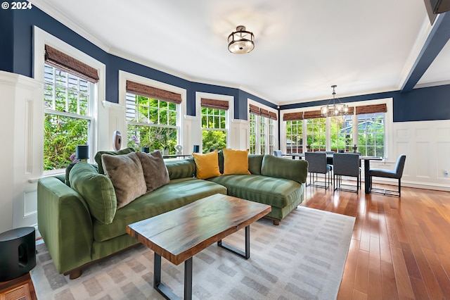 living room with crown molding, hardwood / wood-style floors, and an inviting chandelier