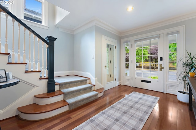 entryway featuring plenty of natural light, ornamental molding, and dark hardwood / wood-style floors