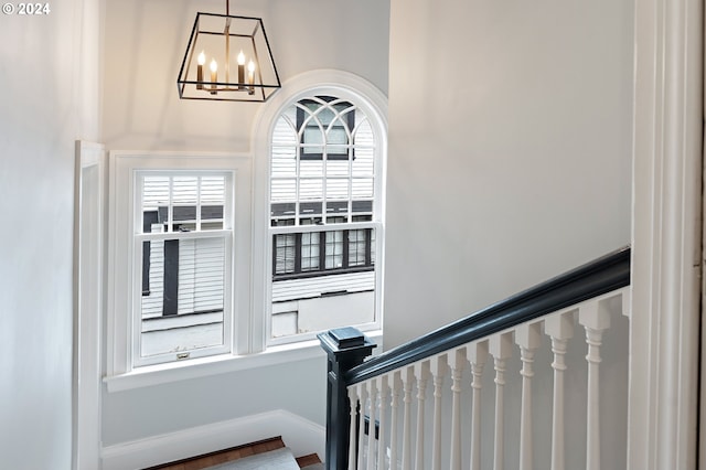 stairs with a notable chandelier