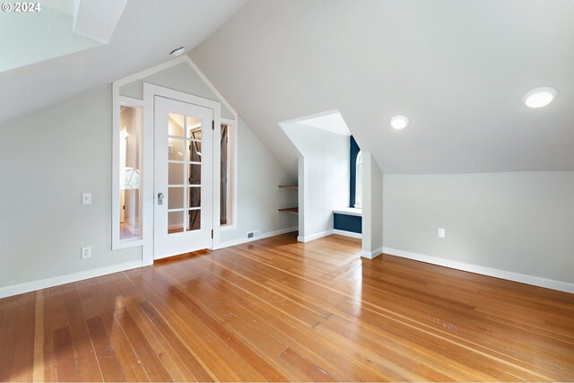 bonus room featuring vaulted ceiling and hardwood / wood-style floors