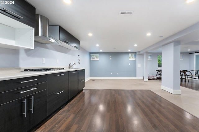 kitchen with stainless steel gas stovetop, sink, light hardwood / wood-style floors, and wall chimney exhaust hood