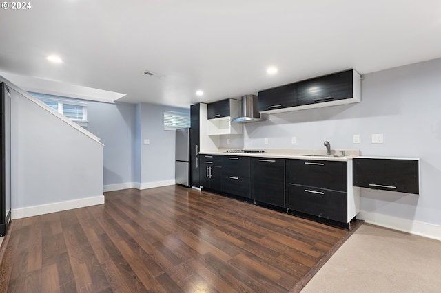 kitchen with sink, stainless steel fridge, gas cooktop, dark wood-type flooring, and wall chimney exhaust hood