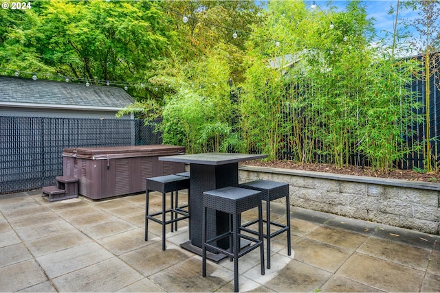 view of patio / terrace with a hot tub and an outdoor bar