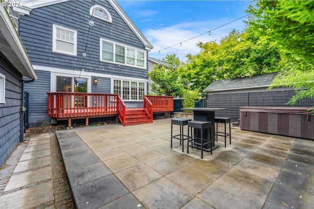 exterior space with a wooden deck, a hot tub, and a patio