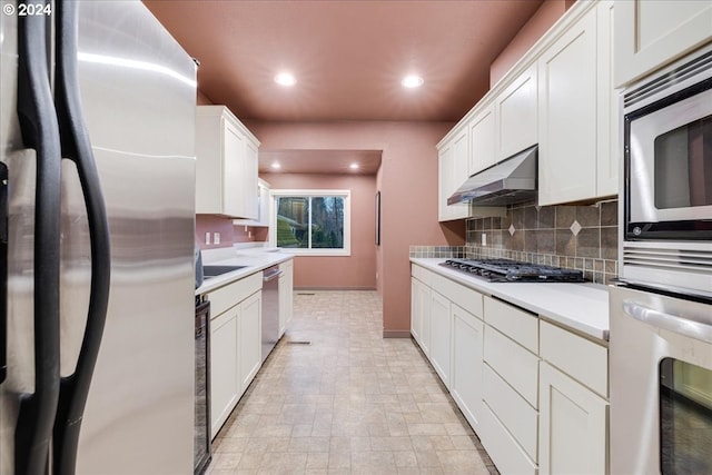 kitchen featuring appliances with stainless steel finishes, white cabinets, and decorative backsplash