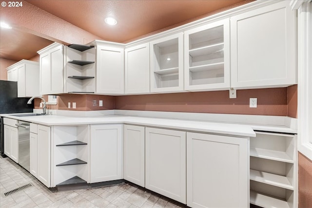 kitchen featuring sink, stainless steel dishwasher, and white cabinets