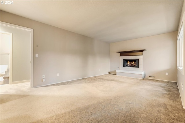 unfurnished living room featuring a fireplace and carpet flooring