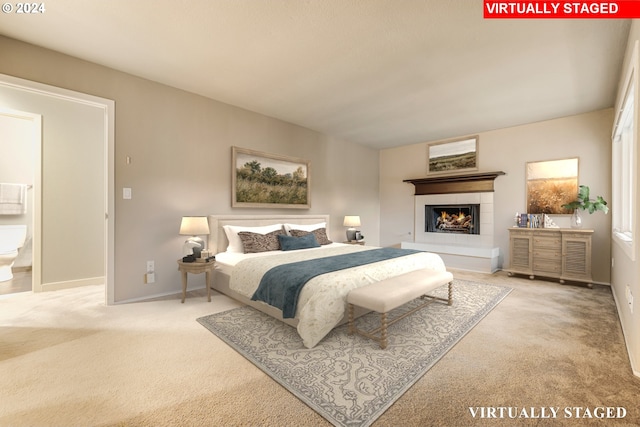 carpeted bedroom with a tiled fireplace