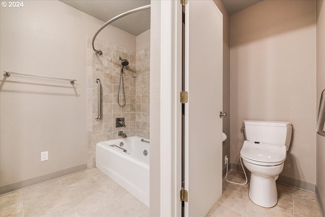 bathroom with tiled shower / bath combo, tile patterned floors, and toilet