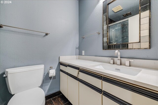 bathroom featuring vanity, toilet, and a shower with shower door