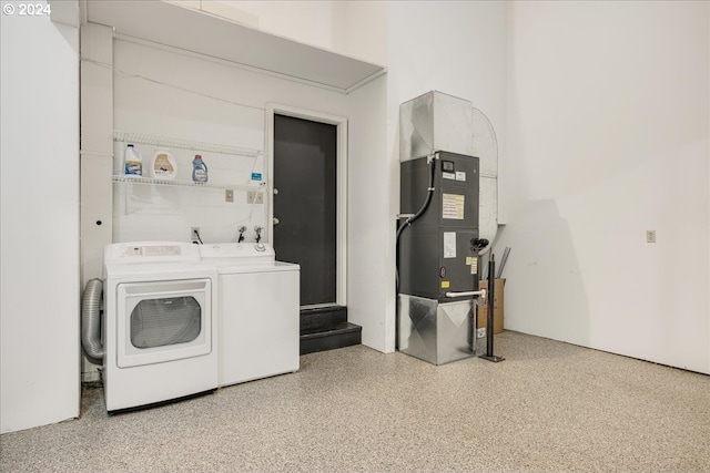 clothes washing area featuring heating unit and separate washer and dryer