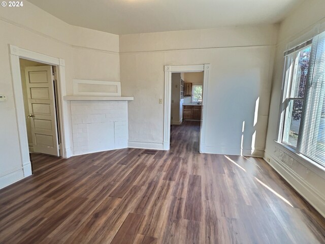 spare room with plenty of natural light and dark wood-type flooring