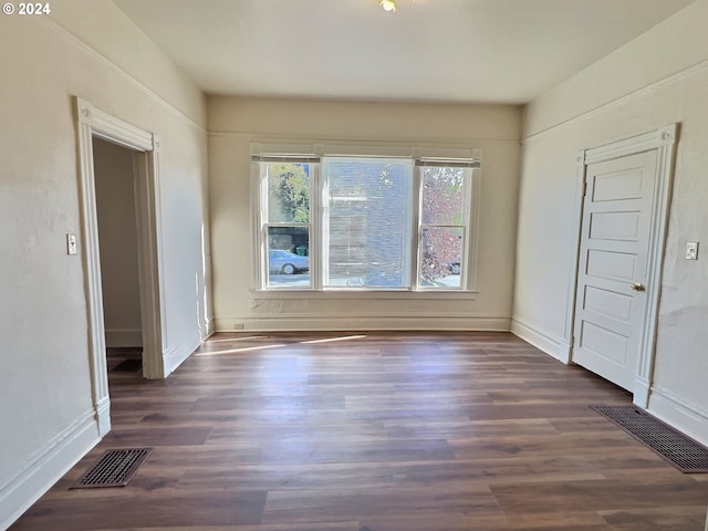 spare room with dark wood-type flooring