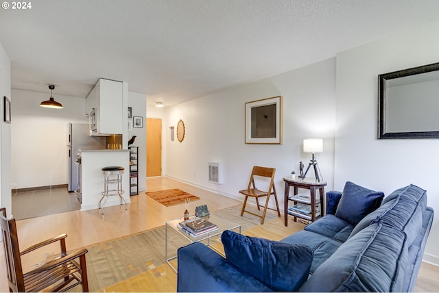 living room featuring a textured ceiling and light hardwood / wood-style floors