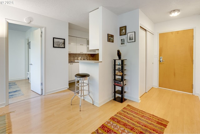 foyer entrance featuring light hardwood / wood-style flooring and a textured ceiling