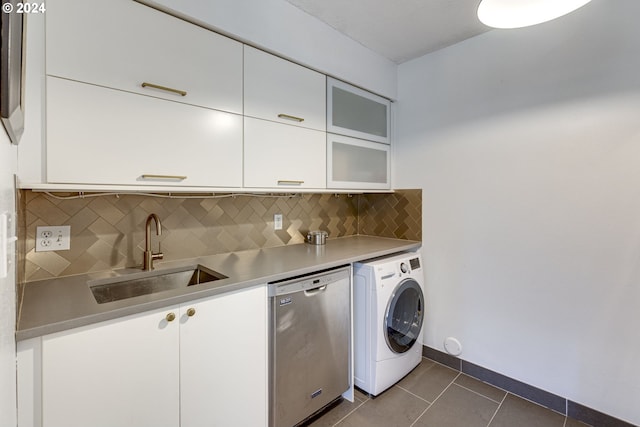 kitchen with sink, stainless steel dishwasher, decorative backsplash, white cabinetry, and washer / clothes dryer