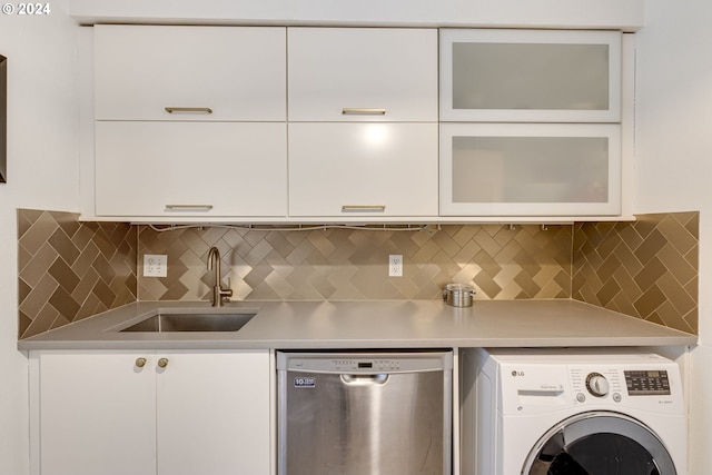 2020 SW Main St Unit 801, Portland, OR 97205 - kitchen with washer / dryer, stainless steel dishwasher, white cabinets, light countertops, and glass insert cabinets