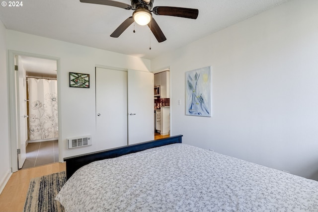 bedroom with ceiling fan, wood-type flooring, and a closet