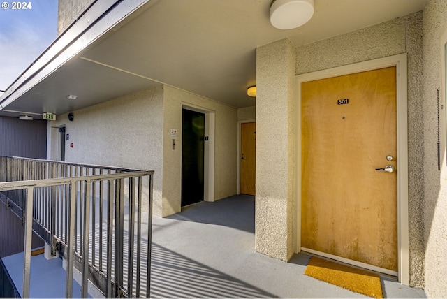 view of exterior entry featuring a balcony