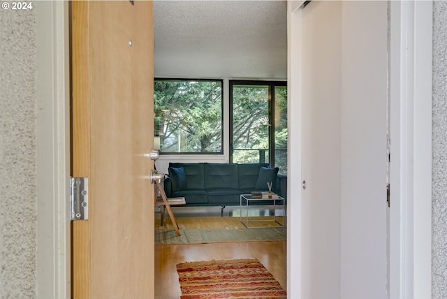 entryway with expansive windows, a textured ceiling, and hardwood / wood-style flooring