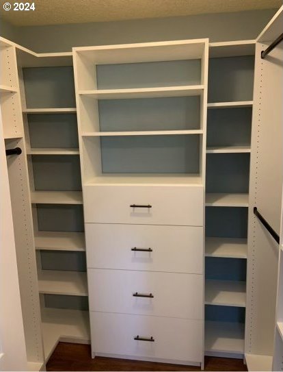 bedroom with multiple closets and dark wood-type flooring