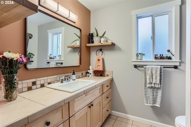 bathroom with vanity, decorative backsplash, toilet, and tile patterned floors