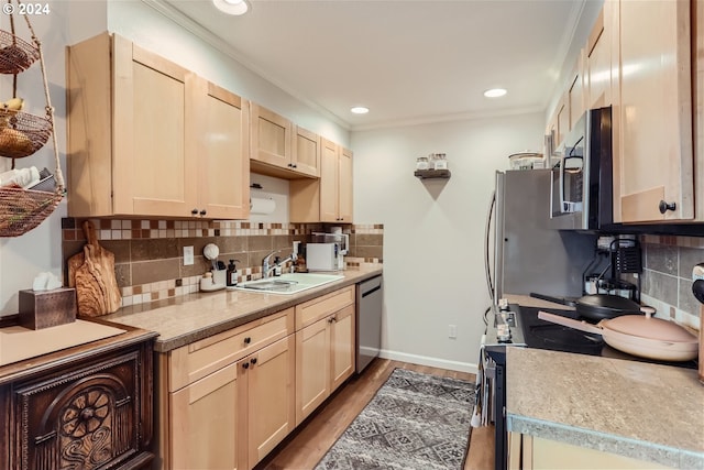 kitchen with appliances with stainless steel finishes, sink, wood-type flooring, light brown cabinetry, and backsplash