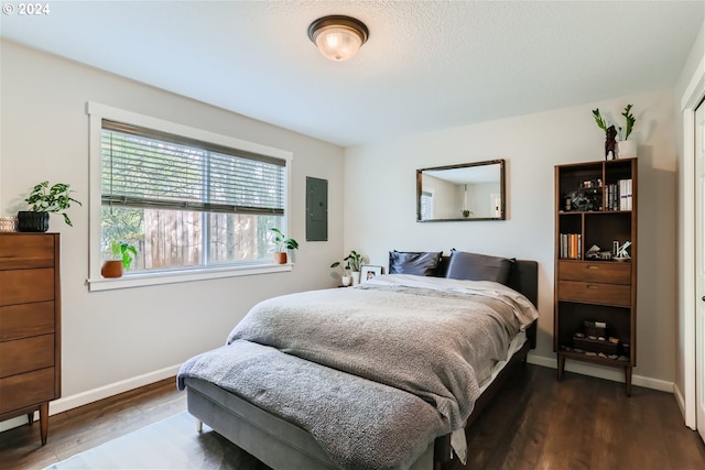 bedroom with electric panel and dark hardwood / wood-style flooring