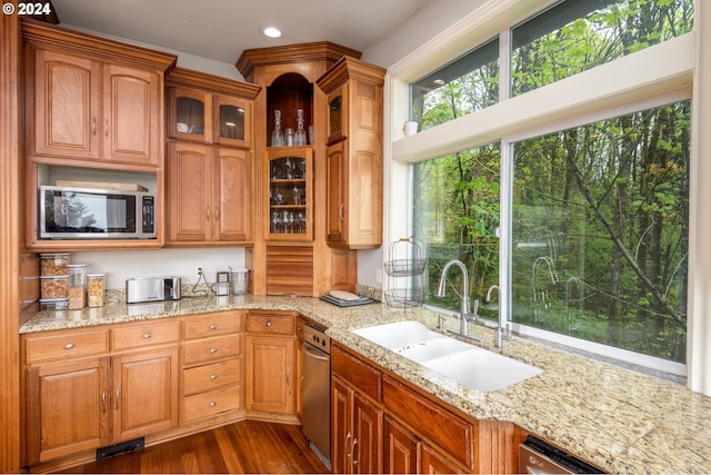 kitchen featuring stainless steel microwave, sink, dark hardwood / wood-style floors, and light stone countertops