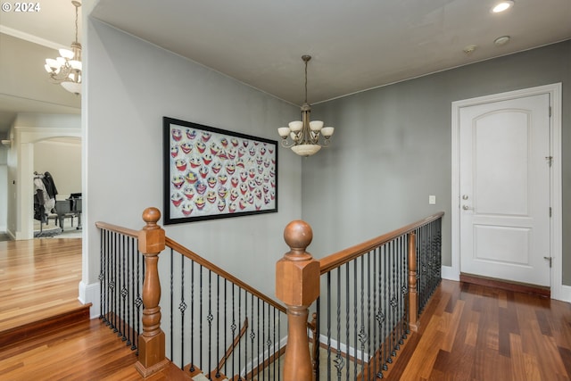 hall with dark hardwood / wood-style flooring and an inviting chandelier